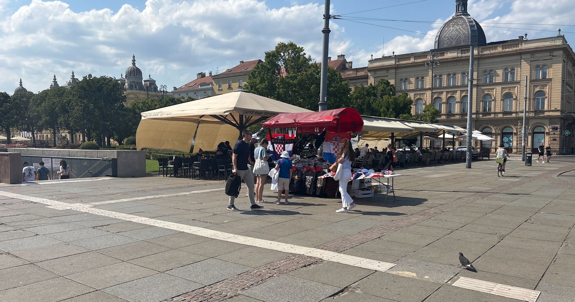 Kod Glavnog kolodvora u Zagrebu štandovi sa zastavama, ljudi kupuju